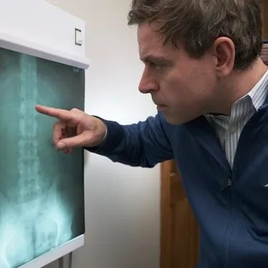 Dr. Lucas Bromley reviews a spinal X-ray on a lightbox at Eagle Creek Chiropractic.