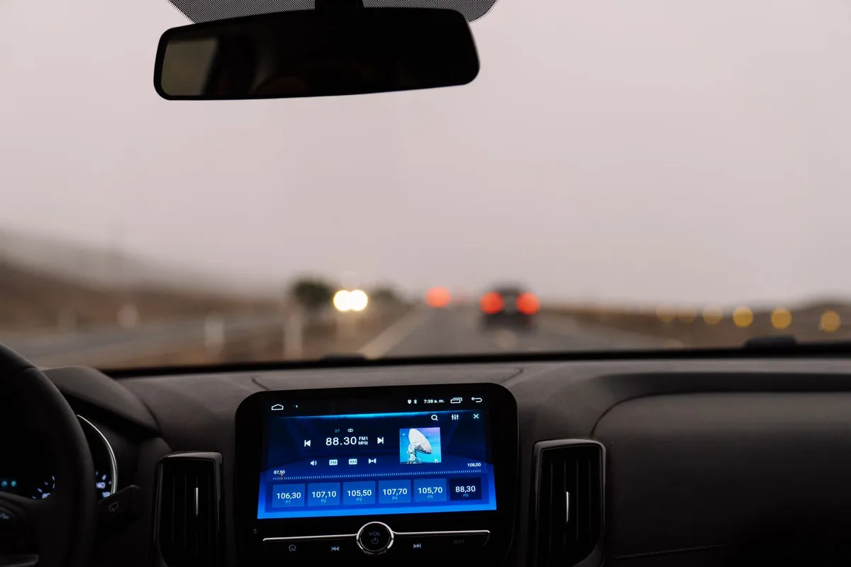 A driver's view through the windshield of a car on an open highway.